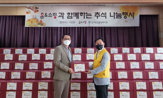 구기대 홈앤쇼핑 사회공헌팀장(오른쪽)이 13일 강서어르신종합복지관에서 임무영 강서노인종합복지관장에게 행복꾸러미를 전달하고 있다. 홈앤쇼핑 제공